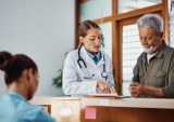 doctor with patient and paperwork