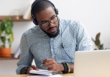 man taking notes in online class