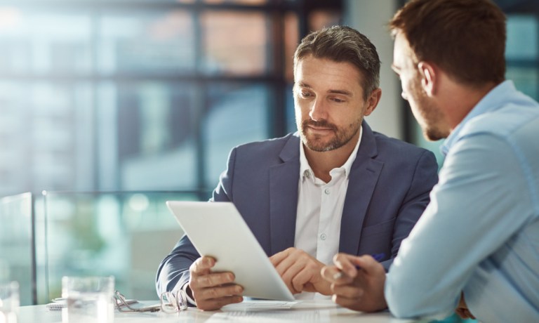 two businessmen looking at tablet