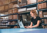 woman in warehouse with laptop