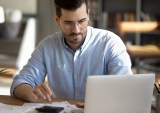 man with laptop and calculator