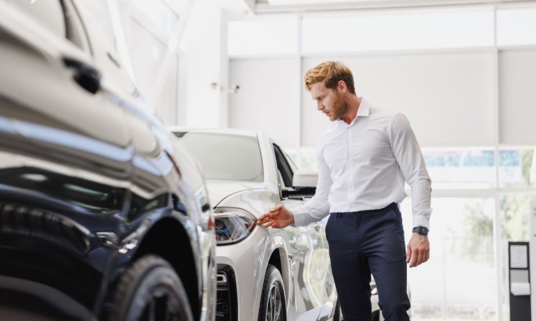 man looking at new cars