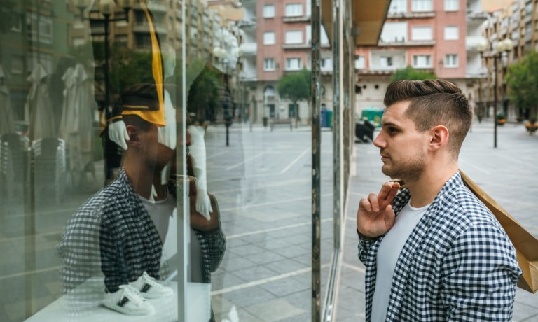 man looking in store window