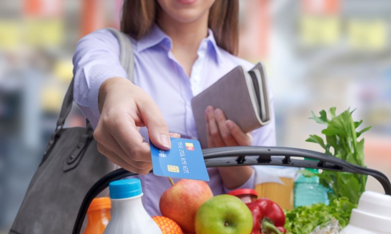 woman paying for groceries with credit card